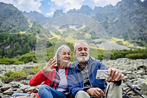 Active senior couple hiking together in autumn mountains.