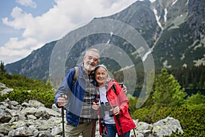 Active senior couple hiking together in autumn mountains.