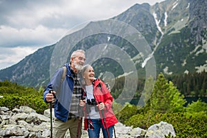 Active senior couple hiking together in autumn mountains.