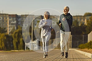 Active Senior Couple Jogging Together in City Park