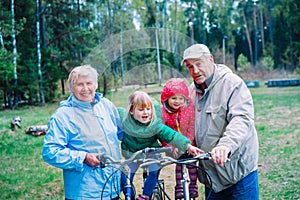 Active senior couple with kids riding bikes in nature