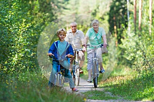 Active senior couple with kids riding bikes in nature