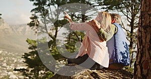 Active senior couple sitting on rock in forest