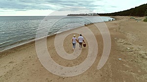 Active senior couple walking through beach together.