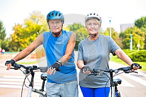 Active senior couple walking with bicycles in park