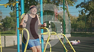 Active senior elderly old caucasian man do physical exercises in sport playground. Fitness leisure. Healthy lifestyle in