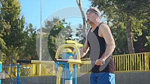Active senior elderly old caucasian man do physical exercises in sport playground. Fitness leisure. Healthy lifestyle in