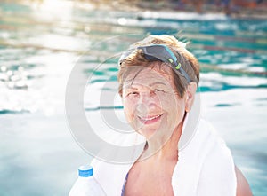 Active senior (elderly) woman (over the age of 50) in sport goggles, with towel, bottle of water.