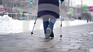 Active senior elderly woman training Nordic walking with trekking poles. Elderly woman practicing Nordic walking