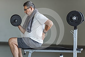 Active senior in gym with back pain