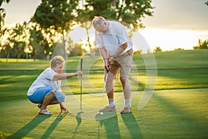 Active senior lifestyle, elderly couple playing golf together