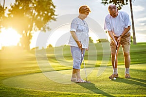 Active senior lifestyle, elderly couple playing golf together