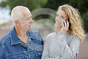 Aktívny senior pri pohľade na dcéru pri telefóne