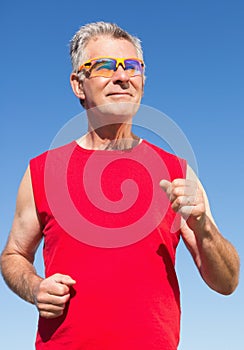 Active senior man jogging on the pier