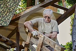 Active senior man in retirement working on the backyard, smiling