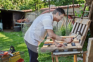 Active senior man in retirement working on the backyard, smiling