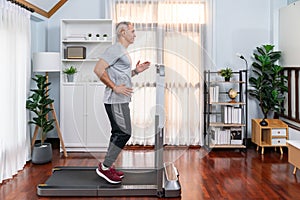 Active senior man running on elliptical running machine. Clout