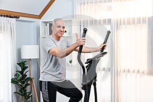 Active senior man running on elliptical running machine. Clout