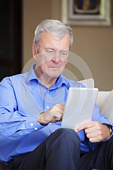Active senior man with tablet