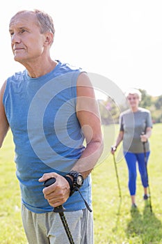 Active senior man walking with woman in park