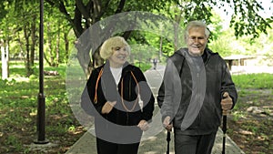 Active senior old couple. Man training Nordic walking, woman running in park