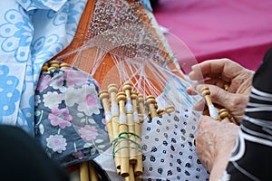 Active senior people workshop with traditional bobbin lace crochet. Hands detail and empty copy space
