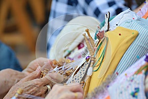 Active senior people workshop with traditional bobbin lace crochet. Hands detail and empty copy space