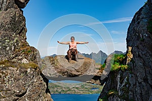 Active Senior tourist woman hiking at the beautiful Rock stuck in mountains Djevelporten. Norway