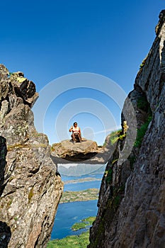 Active Senior tourist woman hiking at the beautiful Rock stuck in mountains Djevelporten. Norway