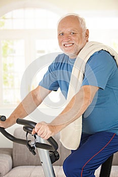 Active senior using exercise bike photo