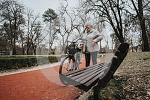 Active senior woman with bicycle enjoying a moment in peaceful park setting