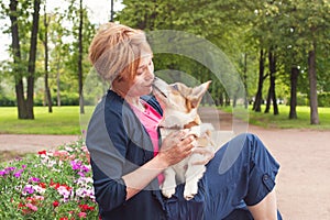 Active senior woman with dog on a walk in a beautiful summer nature