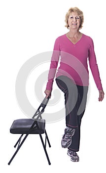 Active senior woman doing chair exercise photo