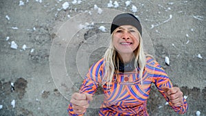 Active senior woman doing exercise outdoors in winter, getting ready for cold therapy.