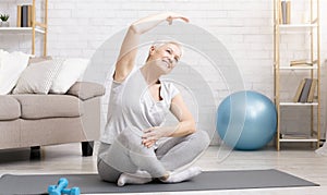 Active senior woman doing exercises at home