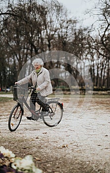 Active senior woman enjoying a bike ride in serene park