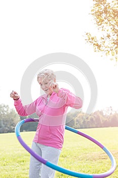 Active senior woman hula hooping in park