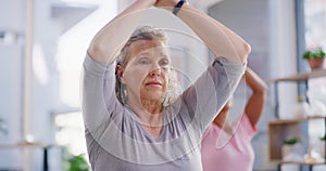 Active senior woman meditating during a fitness class in a yoga studio. Calm, relaxed and focused lady feeling zen while