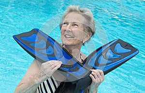 Active senior woman in the pool, doing exercises