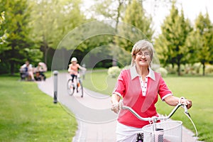 Active senior woman riding bike in a park