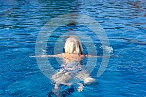 Active senior woman swimming in a pool