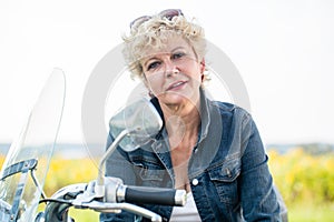 Active senior woman wearing a blue denim jacket while sitting on