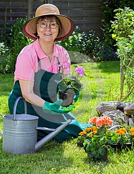 Active senior women working in her garden.