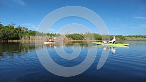 Active senior and young woman kayaking in Everglades National Park 4K.