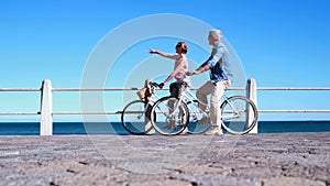 Active seniors going on a bike ride by the sea