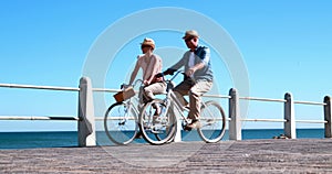 Active seniors going on a bike ride by the sea