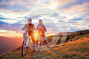 Active seniors having walk with bike in autumn nature. They having romantic time outdoor.