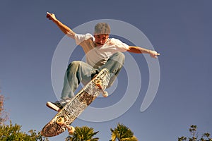 Active skateboarder jumping and performing a trick in a ramp of a skate park