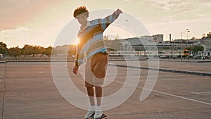 Active skateboarder making trick on board at street. Curly man rolling asphalt