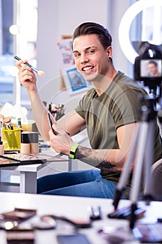 Active skilled man sitting at the beauty table in studio